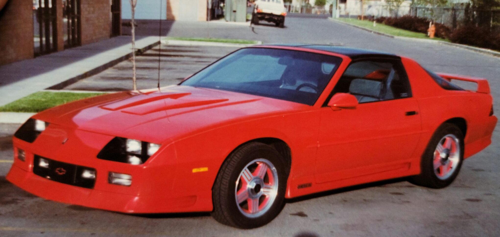 bright red and black vintage car on sidewalk